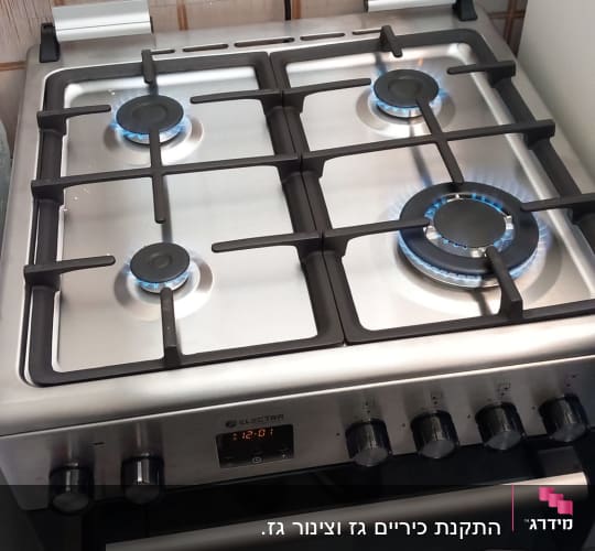 כיריים גז עם ארבעה מבערים דולקים
